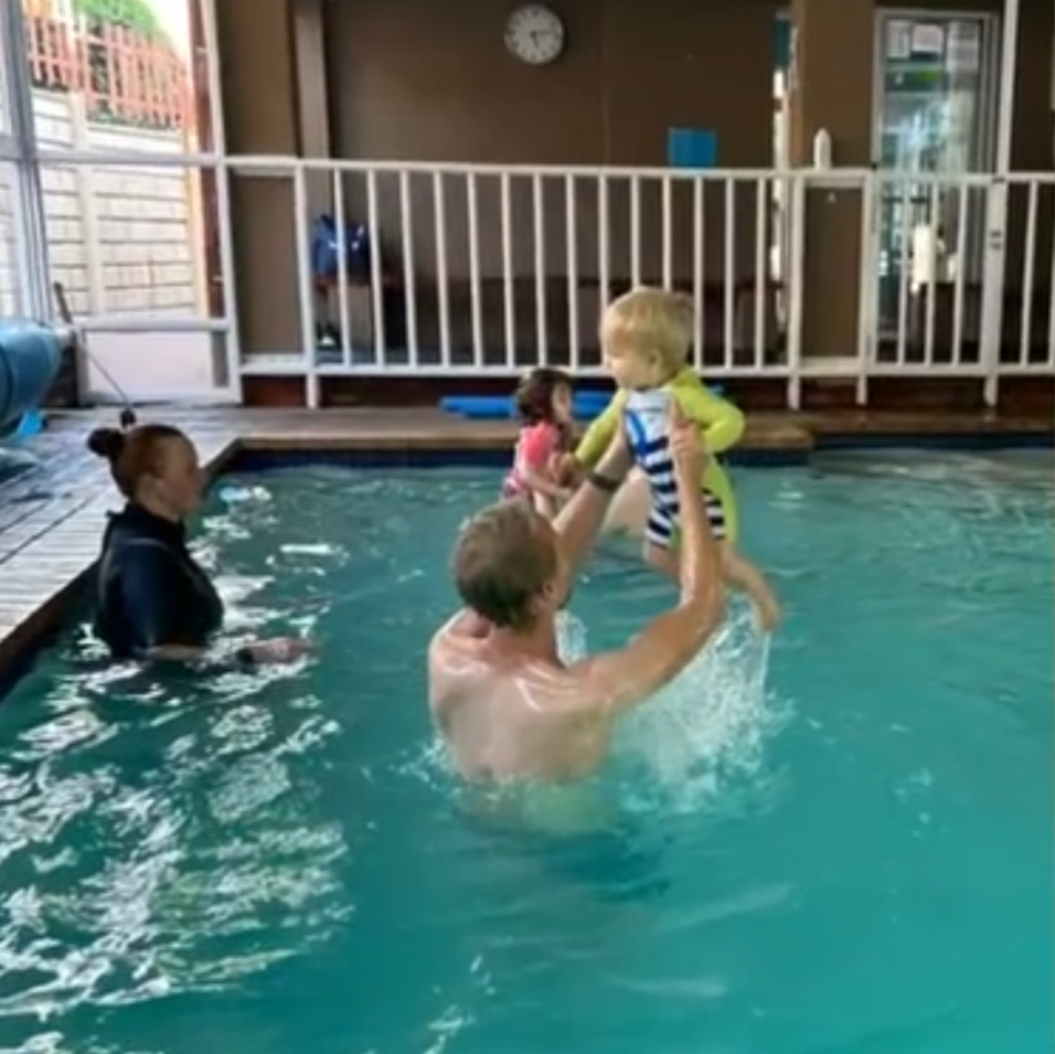 father and son splashing away swim class at splashmates swimschool